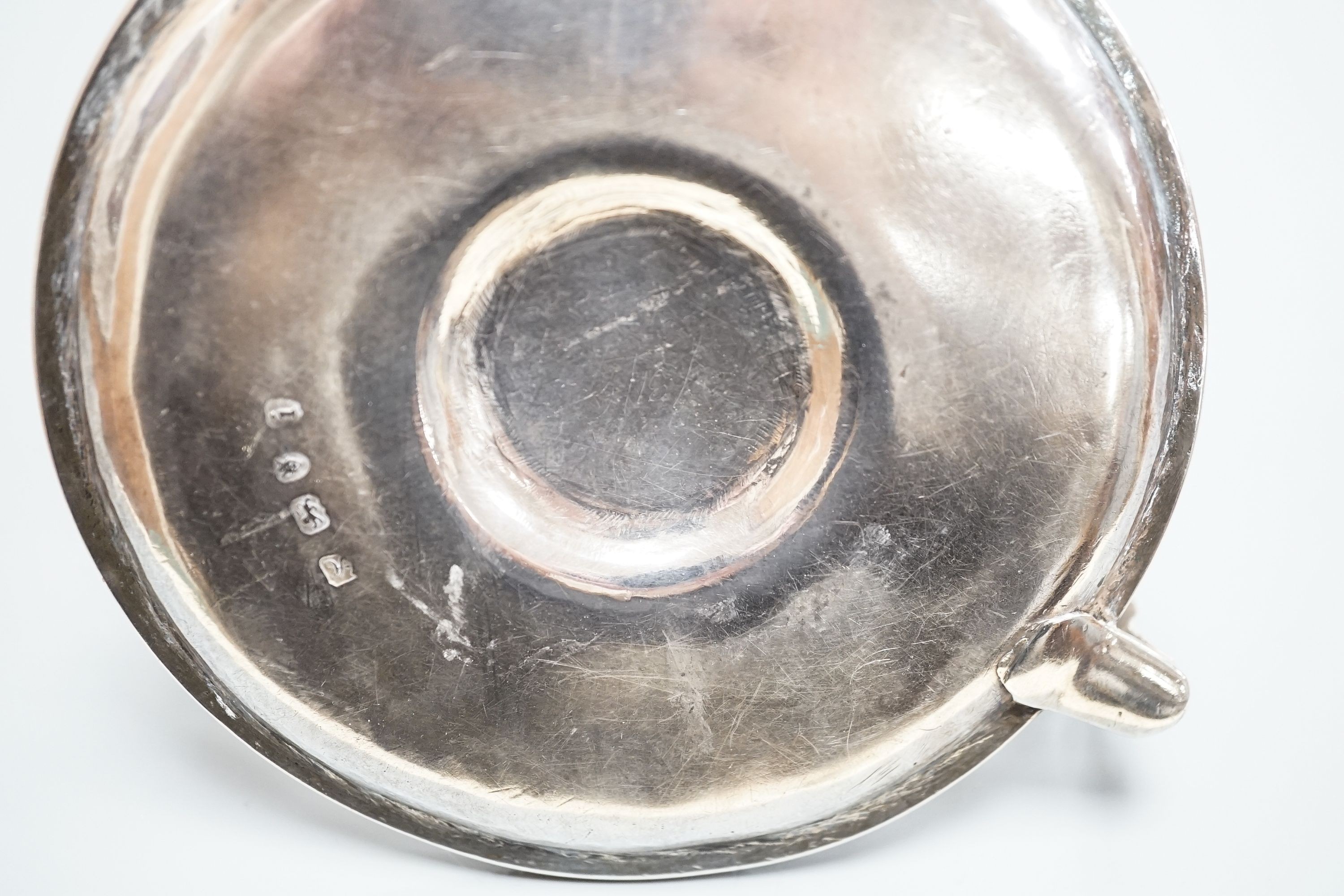 A George III silver chamberstick, by John Arnell, with beaded border and matching sconce and snuffer, London, 1784, diameter 12.8cm, 8oz (a.f.).